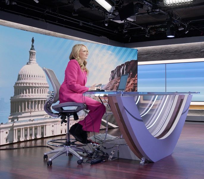 Spectrum News anchor sitting at the anchor desk in the studio