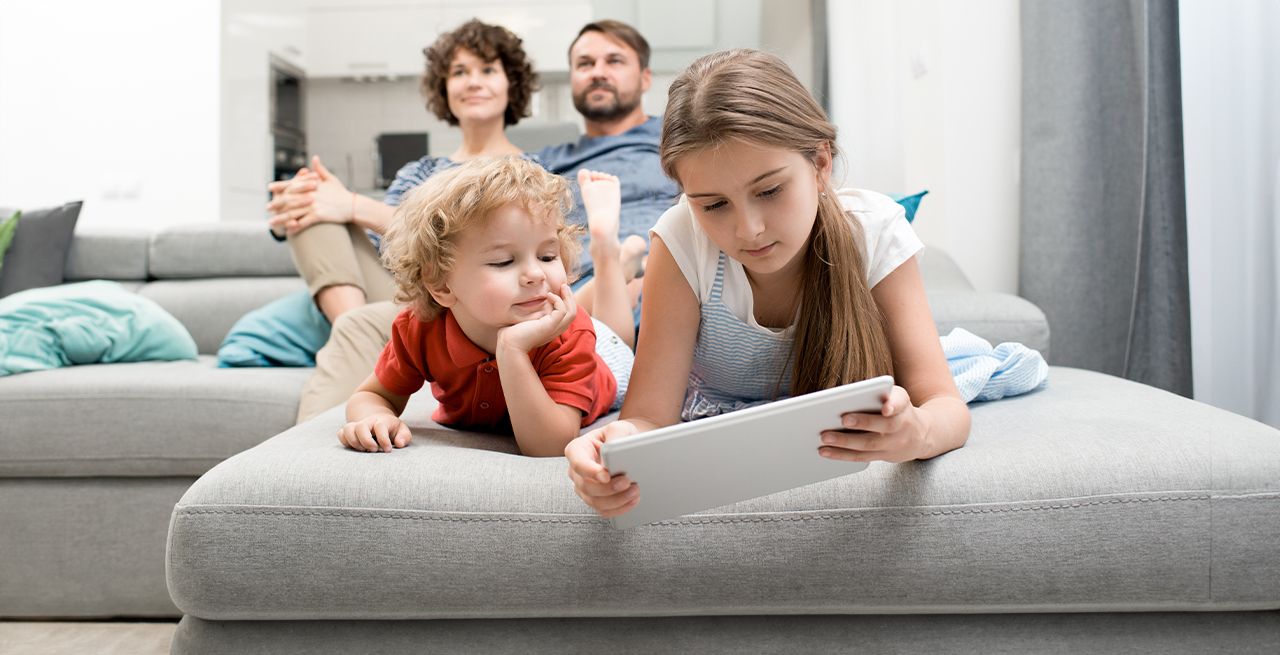 Parents watching TV and kids on device