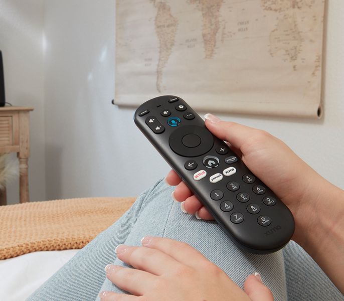 Xumo remote being held in a customers hand in their living room