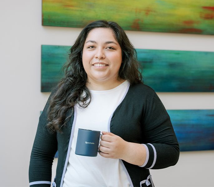 Spectrum Scholar Mariel Segovia enjoying cup of coffee in the office